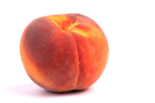 one ripe peach with pulp easily detachable from the seed reddish-yellow in color is shown on a white background close