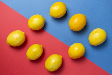Lemons on the bicolor red and blue background. Flat lay citrus. Geometric concept.