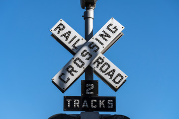 Old railroad crossing two tracks signal sign.