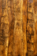 Ein Bretterzaun im Wild West Look aus der Schwarte, bei dem die einzelnen Schwartebretter gegeneinander gedreht und blickdicht überlappend verschraubt sind. Das Holz ist mit farblosem Lack gestrichen