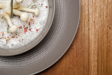 Enoki cream soup in a ceramic bowl, close up. Exquisite dish. Creative restaurant meal. Fine dining concept.	