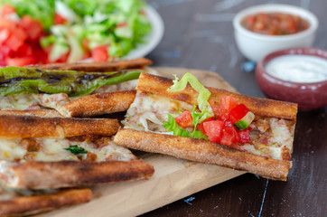 Turkish Pita(pide) with minced meat and cheese and souces.