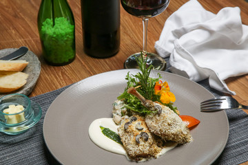 Crispy duck legs served with arugula and decorated with edible flowers. Exquisite dish. Creative restaurant meal concept.