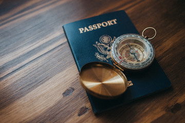 One gold compass on a table with an American passport