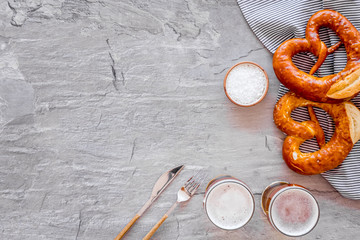 Octoberfest table background. Pretzels and beer glasses on grey background top view copy space frame