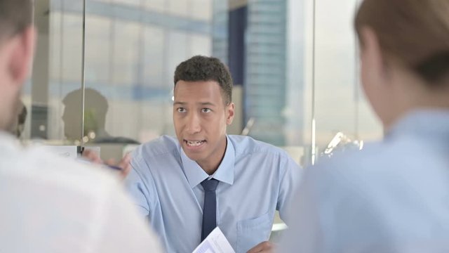 Rear Back View of Couple getting Argument from Businessman on Office Table