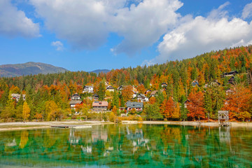 Colorful fall colored woods surround lakefront vacation houses by lake Jasna.