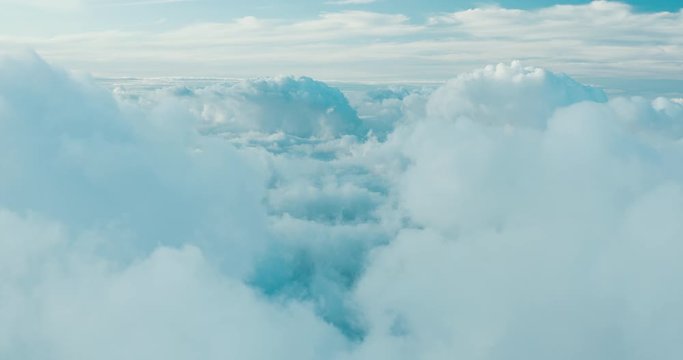 Aerial view flying in the sky above blue and white clouds
