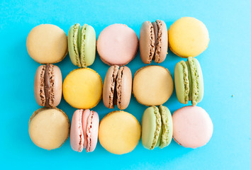 Top view of a colorful french macaron dessert on a blue background
