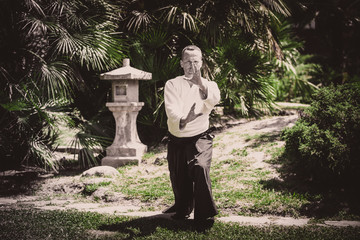 Young serious man aikido master in traditional costume