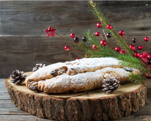 Christmas cake with candied fruits and christmas decorations  on the stump. Stollen is a traditional German cake .