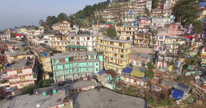 Low aerial orbit around colorful buildings of Dharmasala, India.