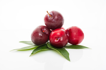 plums with plum leaves on a white background