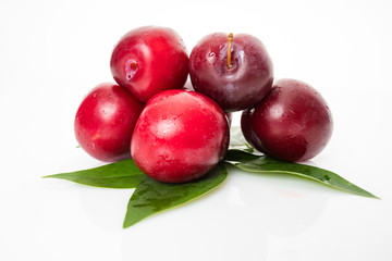 plums with plum leaves isolated on a white background