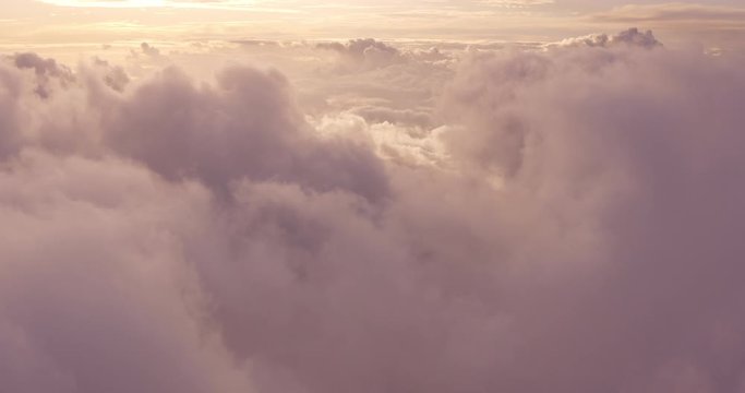 Aerial view flying above the clouds at sunset