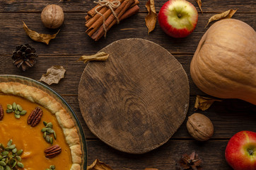 homemade pumpkin pie , pumpkin seeds and autumn leaves on a wooden background