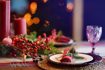 Christmas table set with wreath and red candles. Eve Xmas.