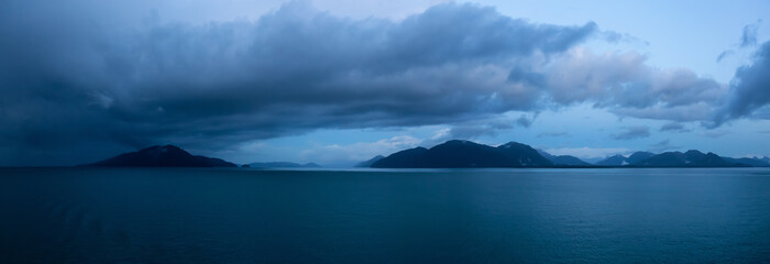 Beautiful Panoramic View of American Mountain Landscape on the Ocean Coast during a cloudy and colorful sunrise in fall season. Taken in Glacier Bay National Park and Preserve, Alaska, USA.