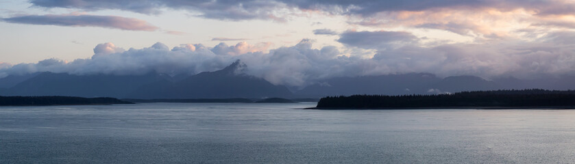 Fototapeta premium Beautiful Panoramic View of American Mountain Landscape on the Ocean Coast during a cloudy and colorful sunrise in fall season. Taken in Glacier Bay National Park and Preserve, Alaska, USA.