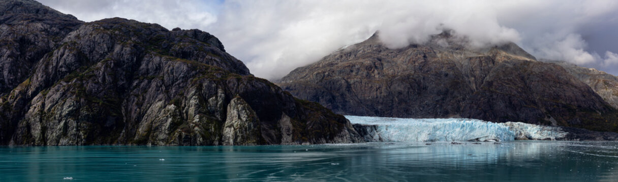 Beautiful Panoramic View of Margerie Glacier in the American Mountain Landscape on the Ocean Coast during a cloudy morning in fall season. Taken in Glacier Bay National Park and Preserve, Alaska, USA.