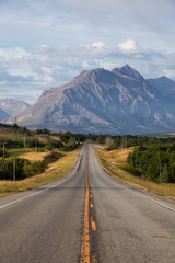 Beautiful View of Scenic Highway with American Rocky Mountain Landscape in the background during a Cloudy Summer Morning. Taken in St Mary, Montana, United States.