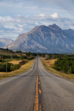 Beautiful View of Scenic Highway with American Rocky Mountain Landscape in the background during a Cloudy Summer Morning. Taken in St Mary, Montana, United States.