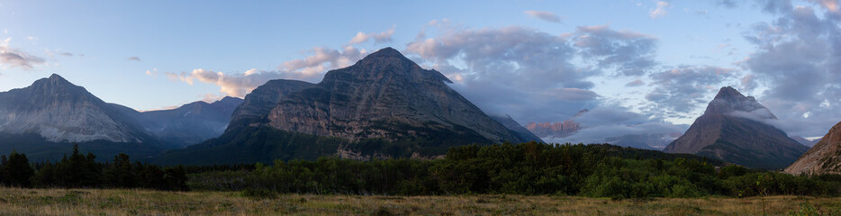 Beautiful Panoramic View of American Rocky Mountain Landscape during a Cloudy Morning Sunrise. Taken in Glacier National Park, Montana, United States.