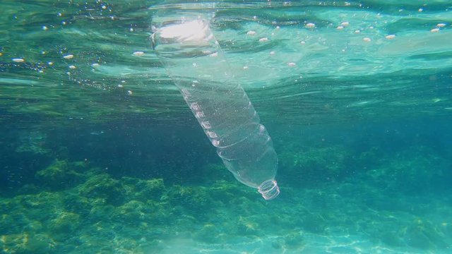 Plastic bottle being dumped in to the sea/ocean.  Pollution in ocean is a big environmental problem. 