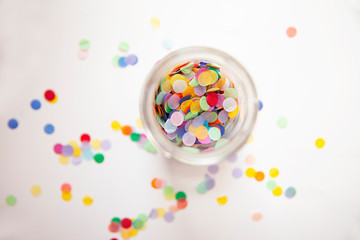 Fototapeta na wymiar Colorful Confetti in a jar on a white background.