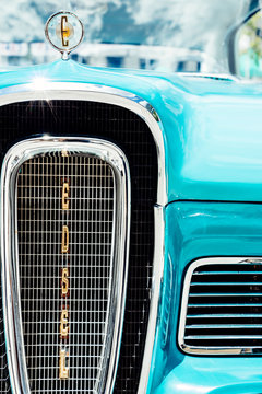 Infamous front grill and hood ornament from a classic blue Ford Edsel.