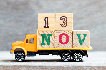 Truck hold letter block in word 13nov on wood background (Concept for date 13 month November)