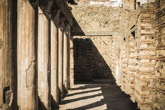 Ancient city Ercolano ruines with columns and geometrical shadows coridor