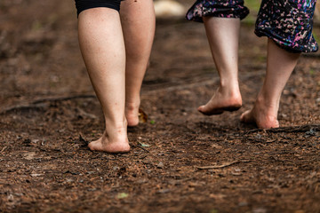 Diverse people enjoy spiritual gathering People walk barefooted on sacred ground during a weekend retreat dedicated to shamanic and native cultures, seen closeup with copy space.