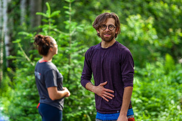 Diverse people enjoy spiritual gathering An enlightened spiritual guy in his thirties is viewed from the front wearing glasses with facial hair, happy and content in nature with copy-space.