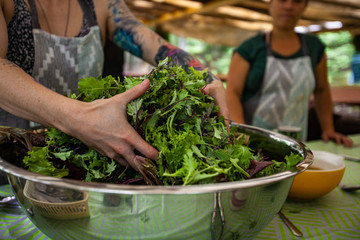 Diverse people enjoy spiritual gathering A close up view on the hands of a caucasian woman with a tattooed arm, preparing healthy food at a woodland retreat promoting healthy body and mind.