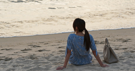 Woman sit on the beach and enjoy the view of the sea