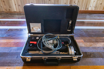 Indoor damp & air quality (IAQ) testing. A close up view of an impactor, with apparatus, accessories, and tubes all stored in a professional hard shell carry case during an in-depth home assessment.