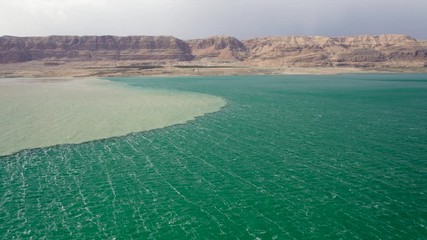 flood muddy water meet turquoise dead sea water, unique phenomenon in Israel, aerial side shot