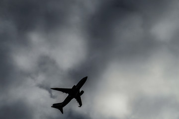 曇天の空と旅客機のシルエット