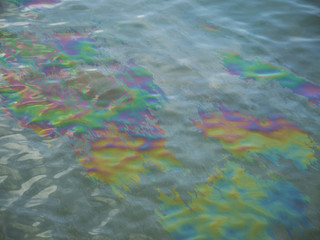 Oil slick seeps from sunken USS Arizona memorial on water surface in Pearl Harbor