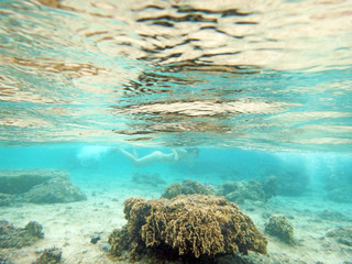 Diving on Guam coral reef, seabed and water surface view form underwater