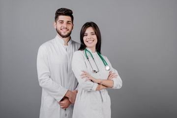 smiling handsome medical doctors in robes smiling isolated over grey