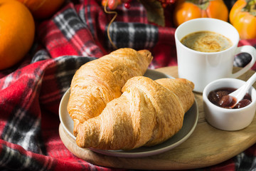 Croissants on a plate with coffee and strawberry jam. pastries for Breakfast
