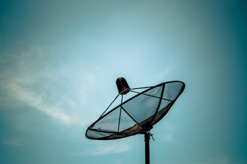 Old satellite dish on blue sky