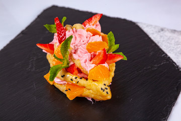 Dessert with fruit on a black plate