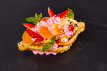 Dessert with fruit on a black plate