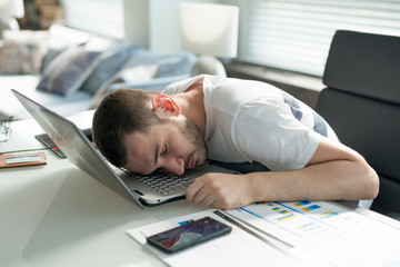 Tired business man sleeping at desk in office