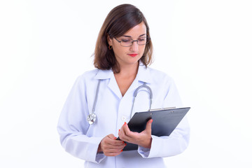 Beautiful woman doctor with eyeglasses reading on clipboard