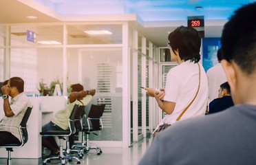 Back view of people sit and waiting in financial transactions in the bank.