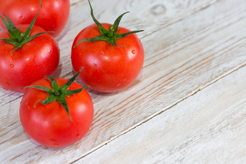 Harvest. Red tomatoes with a green stem. Space for your text.